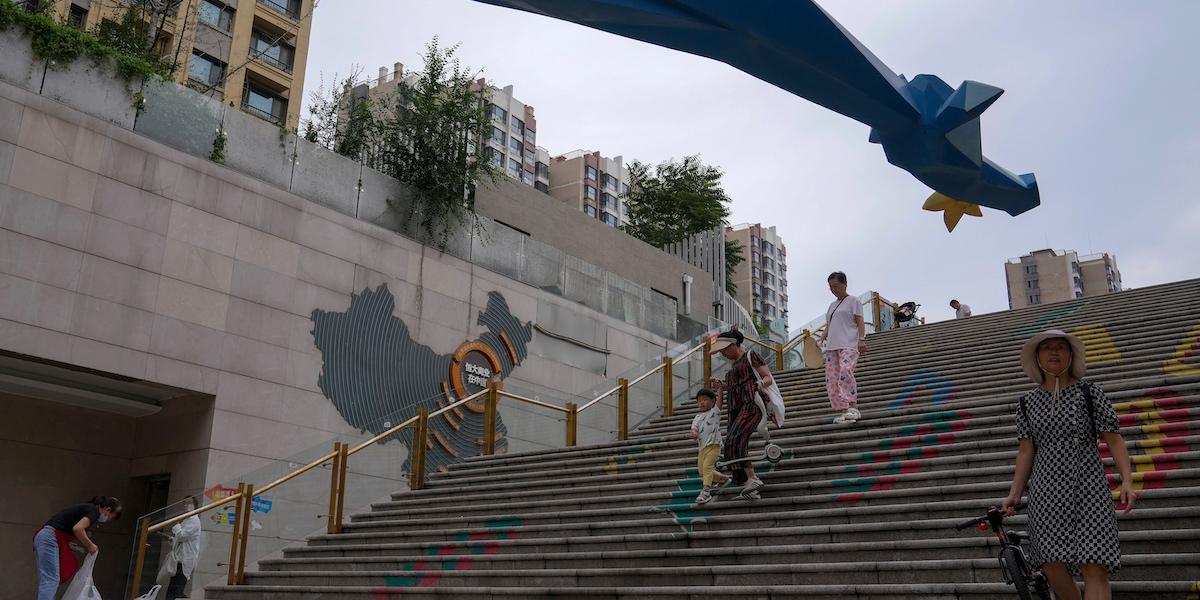 Invånare går förbi en karta som visar Evergrandes utvecklingsprojekt i Kina.