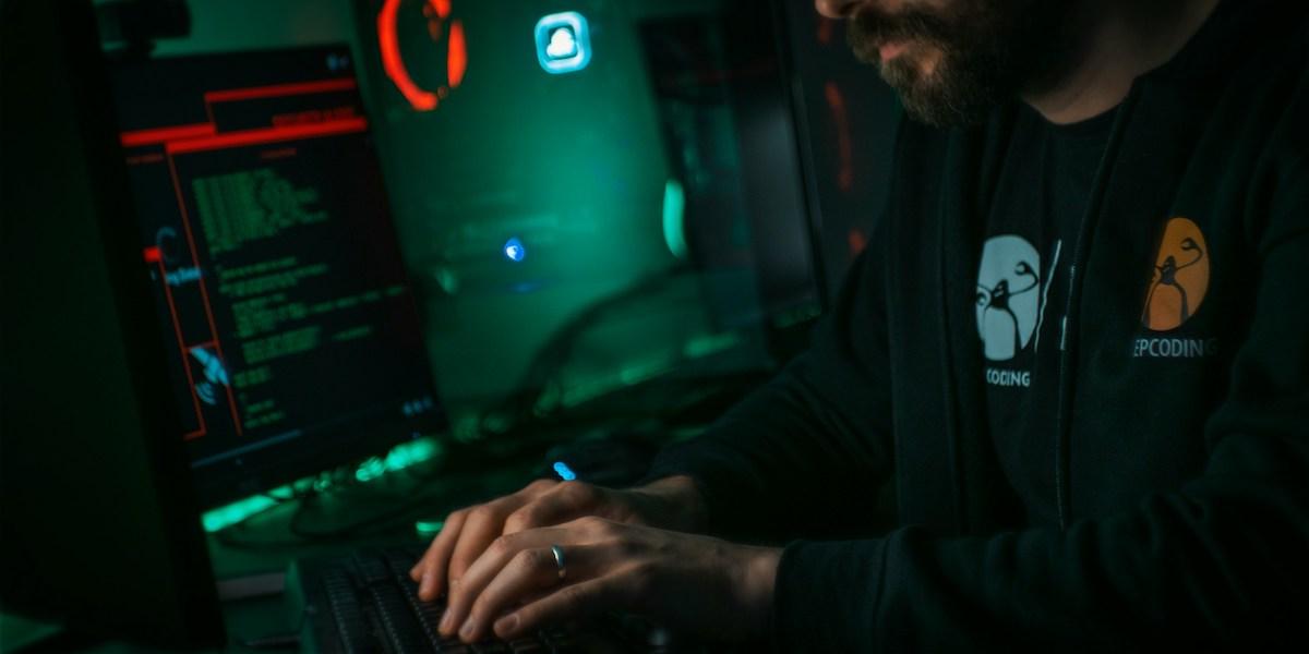 En man sitter framför datorn. Cyberattacker blir allt vanligare och grövre.