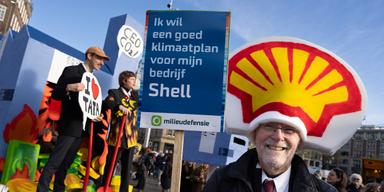 En man håller ett plakat med texten "Jag vill ha en bra klimatplan för mitt företag Shell" under en klimatmarsch för Shell 2023. Men god avkastning går före.