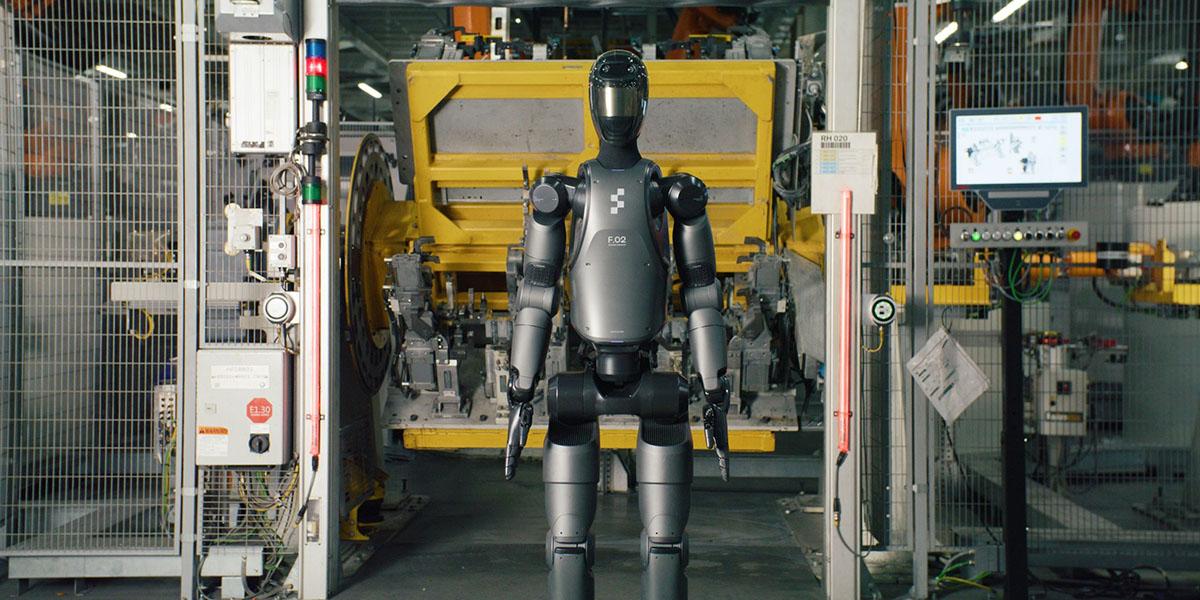 En bild på en humanoid robot som står i en bilfabrik.