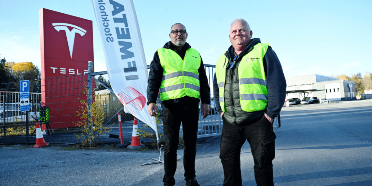 Strejkvakter Thomas Ibrahimsson och Lennart Forsgren vaktar utanför Teslas anläggning i Huddinge. (Foto: Fredrik Sandberg/TT)