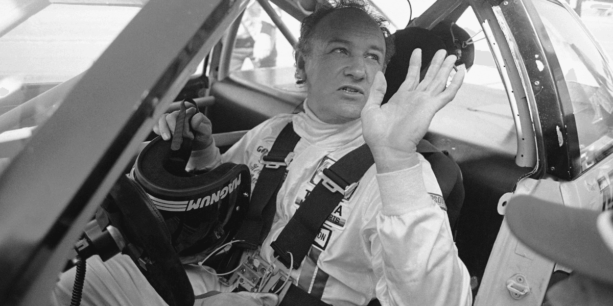 Skådespelaren Gene Hackman vinkar när han ger sig ut på en träningsrunda i sin Toyota Celica den 5 februari 1983 på Daytona International Speedway, som förberedelse inför Daytona 24-timmarsloppet. (Foto: Bob Self/TT)