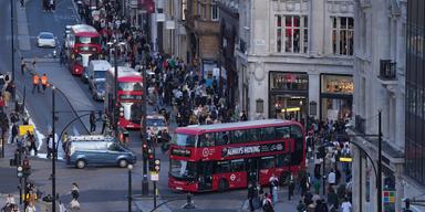 Gatuliv med bussar och folkmassor i centrala London – Storbritanniens ekonomi krympte oväntat i oktober.