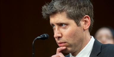 Sam Altman, vd för OpenAI, i närbild under ett offentligt framträdande med mikrofon i förgrunden.